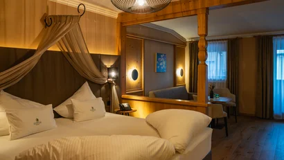 Gemütliches Hotelzimmer mit Bett, Sitzbereich und warmem Licht