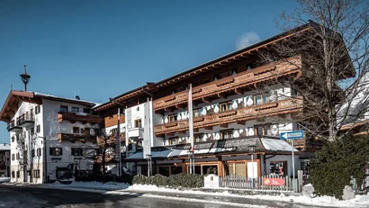 Traditionelles Hotelgebäude mit Holzverzierungen und Schnee bei klarem Himmel