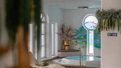 Innenansicht eines Spa-Bereichs mit Whirlpool und Liegestuhl