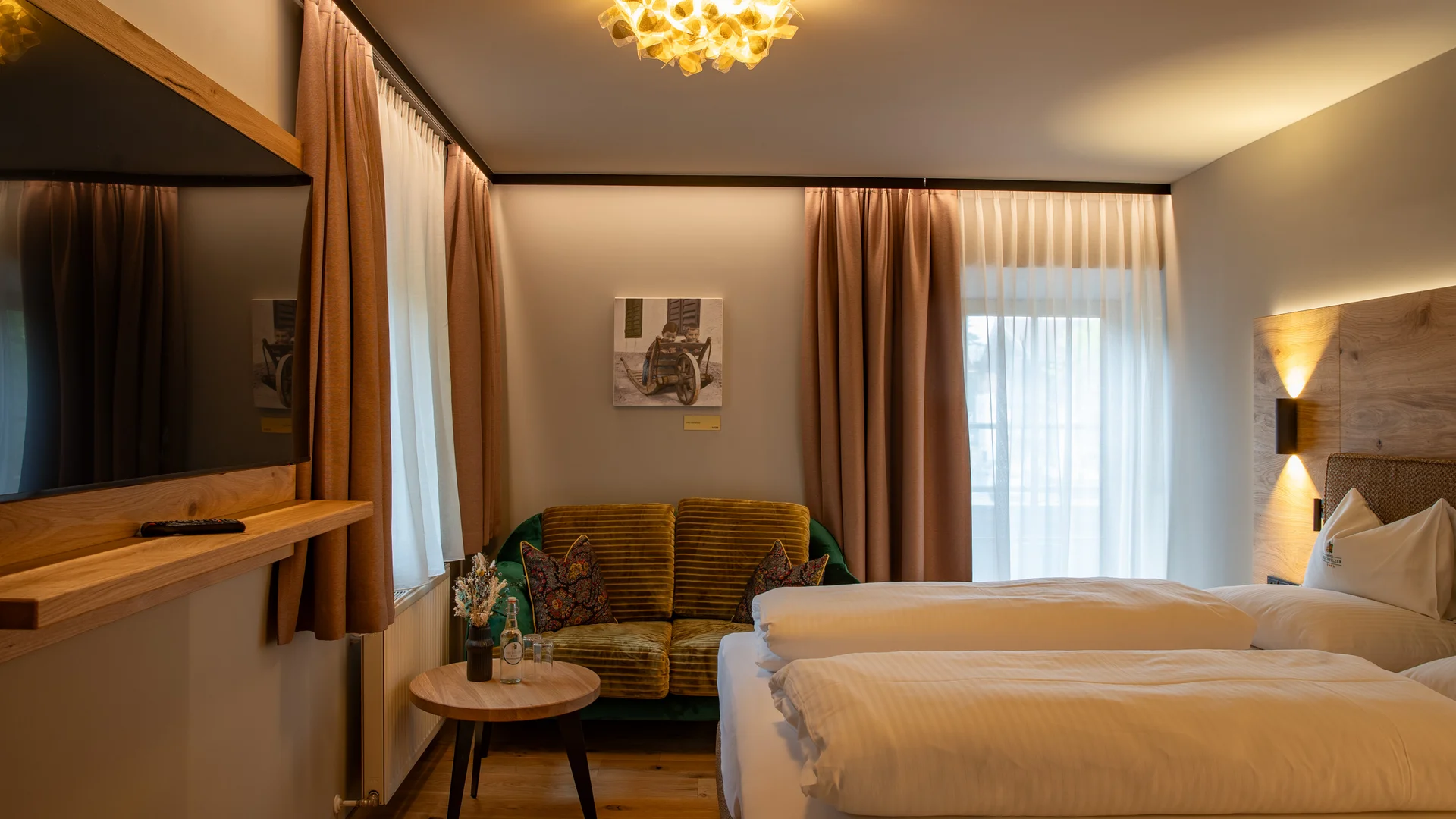 Gemütliches Hotelzimmer mit Doppelbett, Sofa und warmem Licht